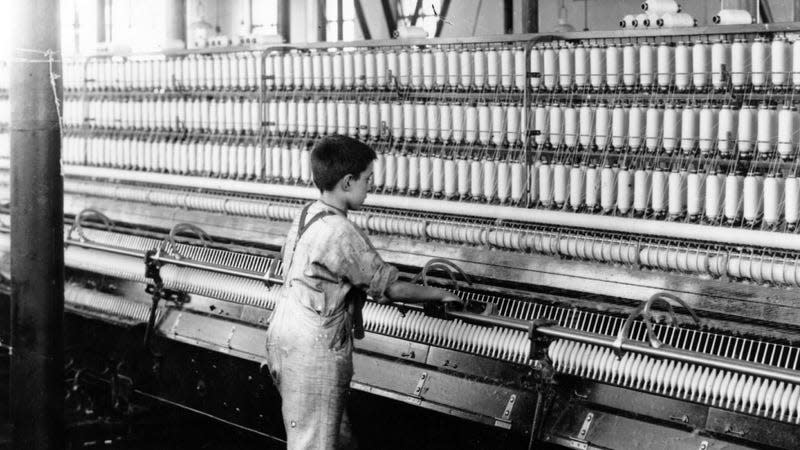 A young boy in England operating a thread-making machine in 1909. - Photo: Topical Press Agency/Hulton Archive (Getty Images)
