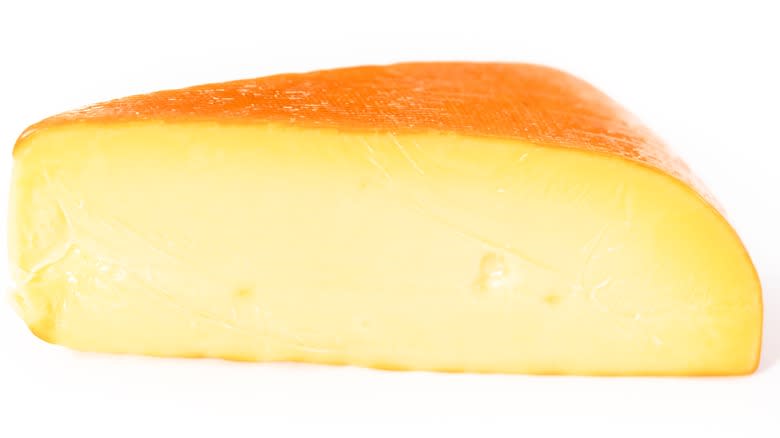 Wedge of Gouda on white background 