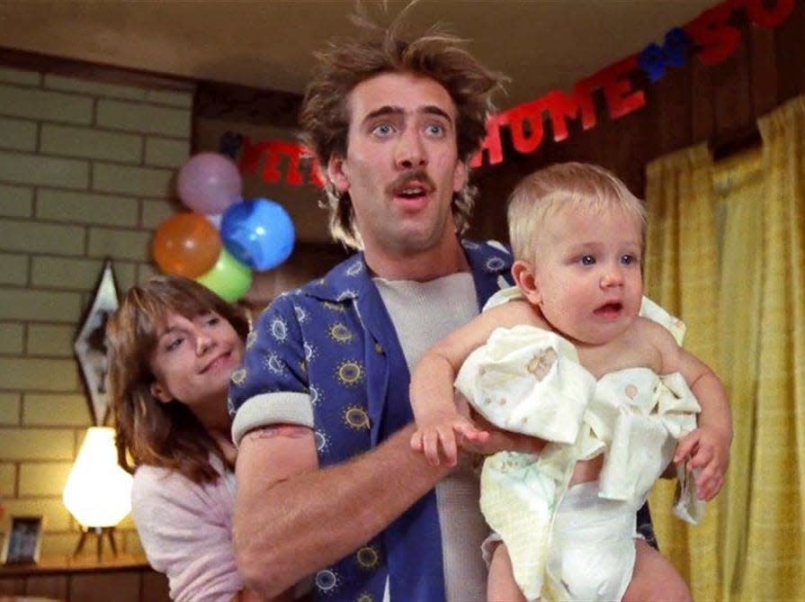 Holly Hunter and Nicolas Cage hold a baby in a scene from "Raising Arizona."
