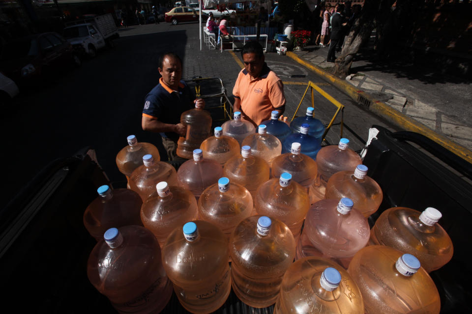 In this Jan. 4, 2014 photo, a vendor, right, prepares to fill his bicycle cart with 18-liter jugs of bottled water to sell to owners of street food stalls in Mexico City. Bad tap water accounts in part for Mexico being the highest consumer of bottled water and sweetened drinks. A law recently approved by Mexico City’s legislators will require all restaurants to install filters, offering patrons free, apparently drinkable potable water that won’t lead to stomach problems and other ailments. With an obesity epidemic looming nationwide, the city’s health department decided to back the water initiative. (AP Photo/Marco Ugarte)