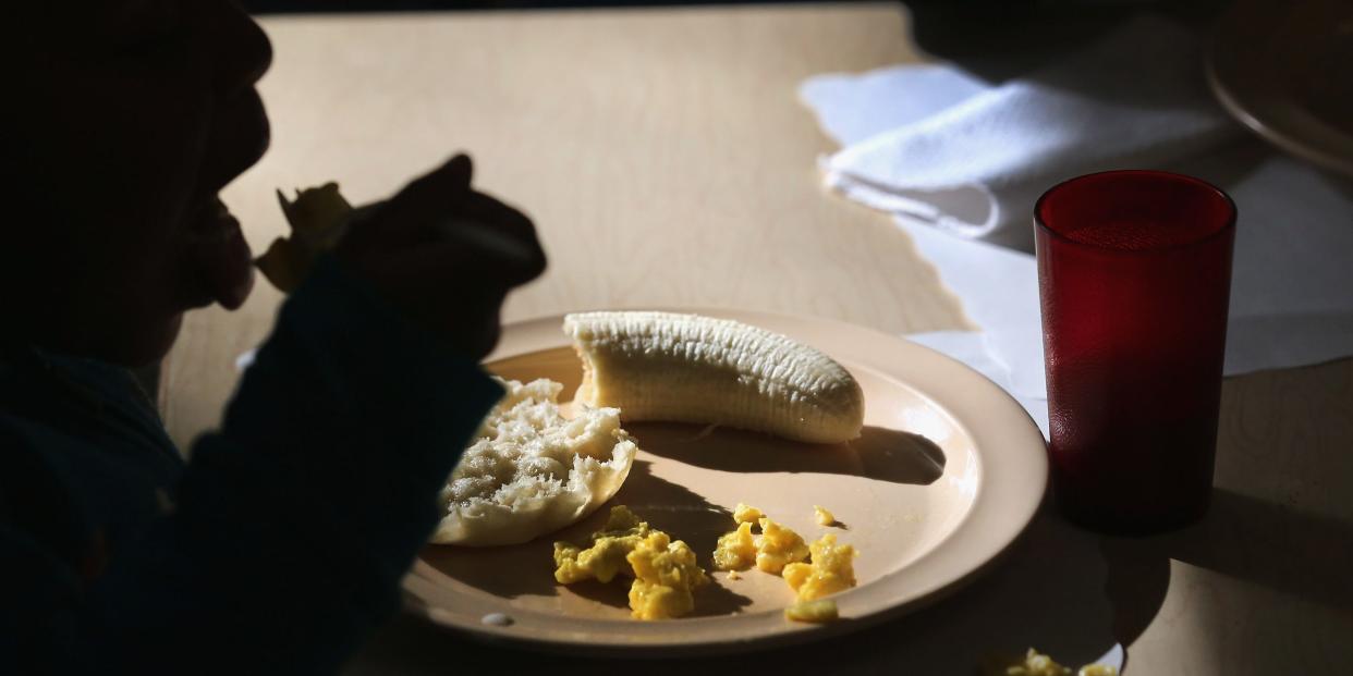 child eating next to plate with banana on it