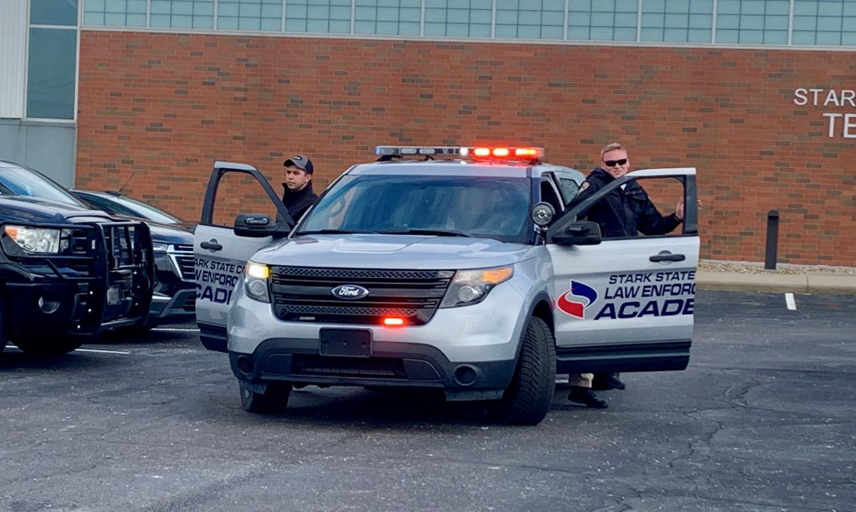Canton City police cadets Brandon Robb, left, and Ty Cowling exit a training cruiser in February during a training scenario at the Stark State College law enforcement academy in Jackson Township.