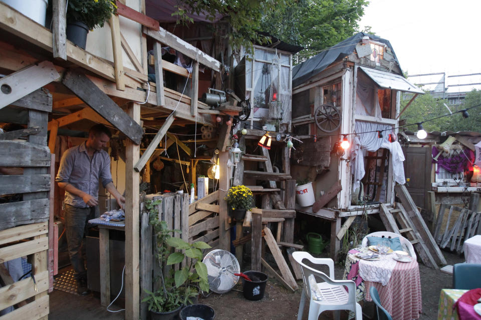 British set designer Tony Hornecker prepares dinner at his restaurant "The Pale Blue Door" in Berlin, September 12, 2010. A British set designer has taken his love for art, added some food, and opened a temporary pop-up restaurant -- made with scrap materials scavenged from the streets -- in one of Berlin's central community gardens. Tony Hornecker, the mastermind behind the thriving shanty town-style restaurant "The Pale Blue Door", said that he does not make any profits with his fanciful underground restaurant, but feels that he is giving Berlin a unique attraction. REUTERS/Tobias Schwarz