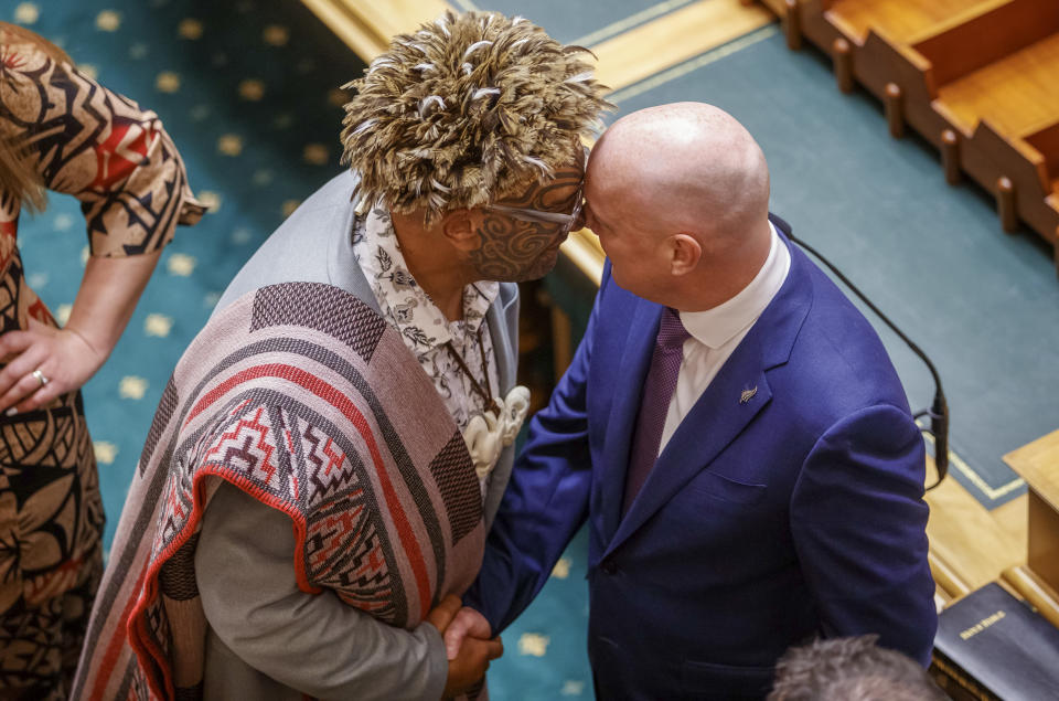 New Zealand Prime Minister Christopher Luxon, right, shakes hands and performs a hongi with Te Pati Maori co-leader Rawiri Waiti in the chamber during the Swearing-in ceremony at Parliament in Wellington, New Zealand, Tuesday, Dec. 5, 2023. Thousands of protesters rallied against the New Zealand government's Indigenous policies on Tuesday as the Parliament convened for the first time since October elections. (Mark Mitchell/New Zealand Herald via AP)