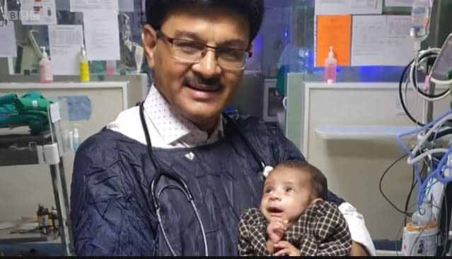 Indian doctor Ravi Khanna holding the baby girl who was found buried alive.