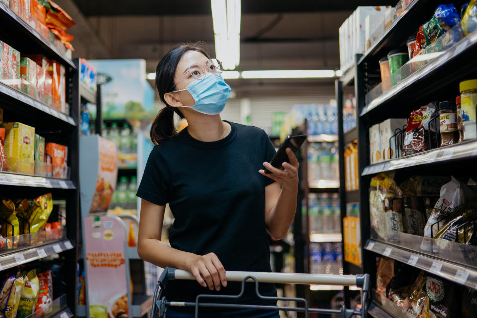 A woman in the grocery store with her phone in her hands