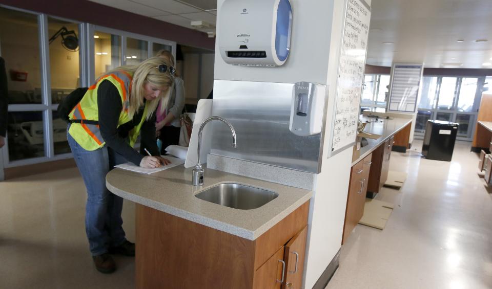 Mary Azelton, resident engineer of the project from the U.S. Army Corps of Engineers, takes notes as she and others tour the currently closed St. Luke's Medical Center hospital to see the viability of reopening the facility for possible future use due to the coronavirus, Wednesday, March 25, 2020, in Phoenix. (AP Photo/Ross D. Franklin)
