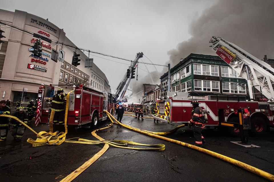 Firefighters from numerous area departments battle a multi-alarm fire on South Main St. in Port Chester April 17, 2023. The fire started in 16 South Main Street and spread to 14 and 12. The structures were three-story vacant apartment buildings on top of businesses that the Port Chester Fire Chief said were vacant and scheduled for demolition. 