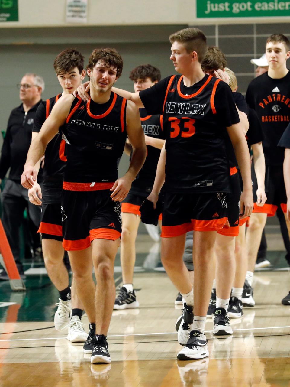 New Lexington senior Lukas Ratliff, left, is consoled by classmate Brody Agriesti as the Panthers exited the floor following a 58-41 season-ending loss to Fairfield Union in a Division II district final on March 5, 2023, at The Convocation Center in Athens. Ratliff scored a team-high 19 points with five 3-pointers as New Lex finished 21-5.