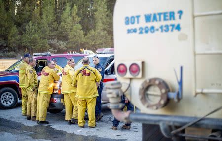 Firefighters from Cal Fire confer while battling the King Fire burn near Fresh Pond, California September 17, 2014. REUTERS/Noah Berger