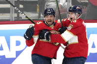 Florida Panthers center Sam Reinhart (13) celebrates with center Anton Lundell (15) after scoring a goal during the third period of Game 3 of an NHL hockey Stanley Cup first-round playoff series against the Boston Bruins, Friday, April 21, 2023, in Sunrise, Fla. (AP Photo/Lynne Sladky)