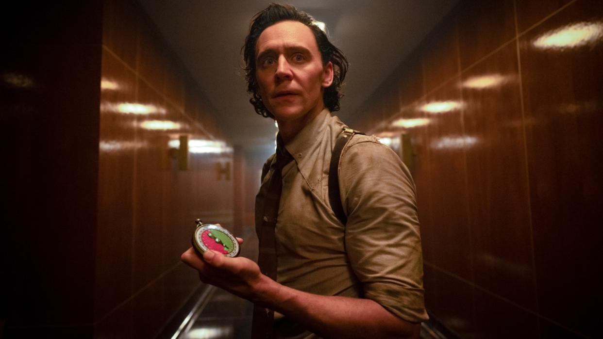  A press image of Tom Hiddleston as Loki holding a compass like object in Season 2. 