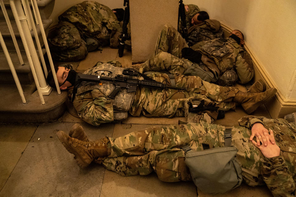 WASHINGTON, DC - JANUARY 13: Members of the National Guard sleep in the halls of Capitol Hill as the House of Representativs convene to impeach President Donald Trump, nearly a week after a pro-Trump insurrectionist mob breached the security of the nations capitol while Congress voted to certify the 2020 Election Results on Wednesday, Jan. 13, 2021 in Washington, DC. (Kent Nishimura / Los Angeles Times via Getty Images)