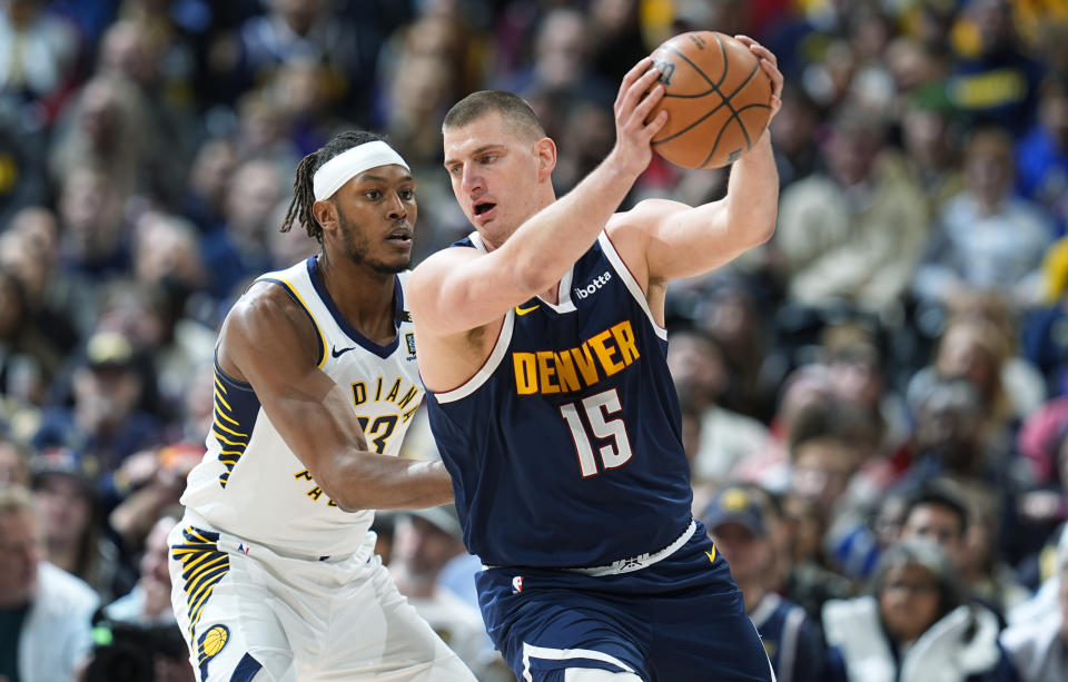 Denver Nuggets center Nikola Jokic, right, pulls in a pass as Indiana Pacers center Myles Turner, left, defends in the first half of an NBA basketball game Sunday, Jan. 14, 2024, in Denver. (AP Photo/David Zalubowski)