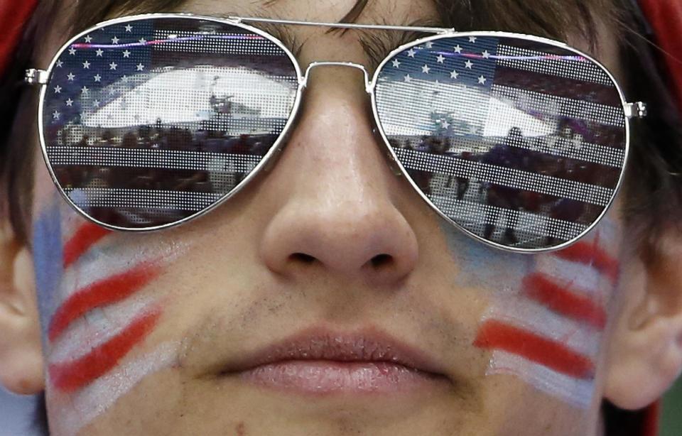 A U.S. hockey fan watches the USA and Russia men's hockey teams warm up before playing in a men's ice hockey game at the 2014 Winter Olympics, Saturday, Feb. 15, 2014, in Sochi, Russia. (AP Photo/Julio Cortez)