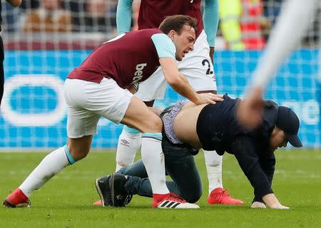 Soccer Football - Premier League - West Ham United vs Burnley - London Stadium, London, Britain - March 10, 2018 West Ham United's Mark Noble clashes with a fan who invades the pitch REUTERS/David Klein