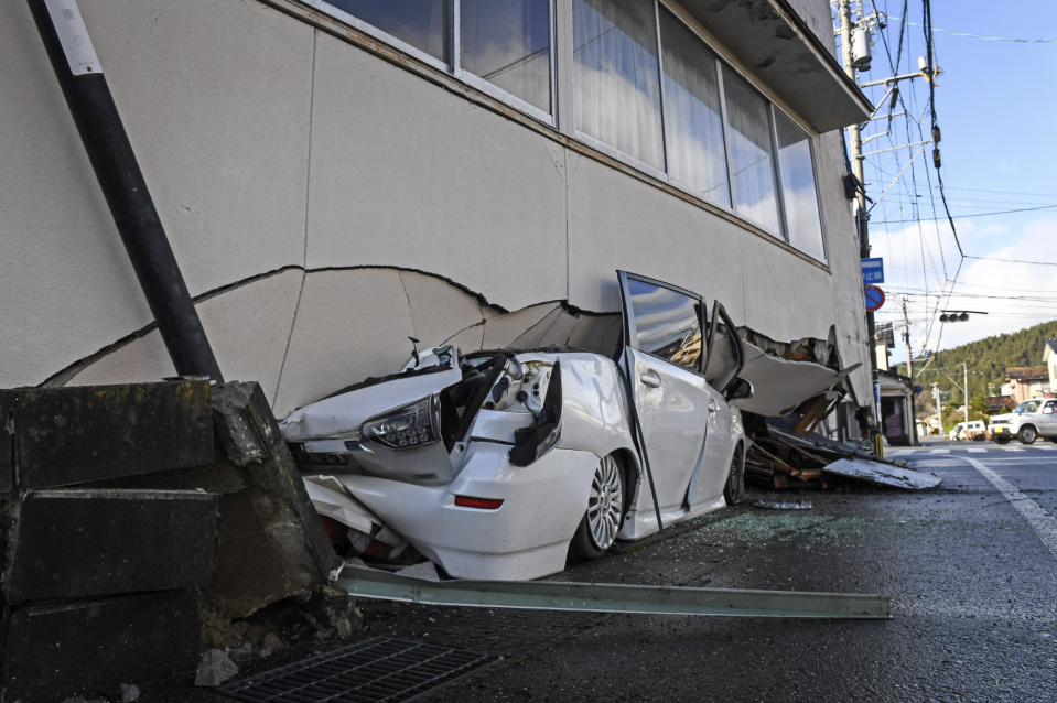 受能登半島7.6級地震及連日多次餘震影響，日本石川多棟房屋及汽車嚴重損毀變形。（AFP）
