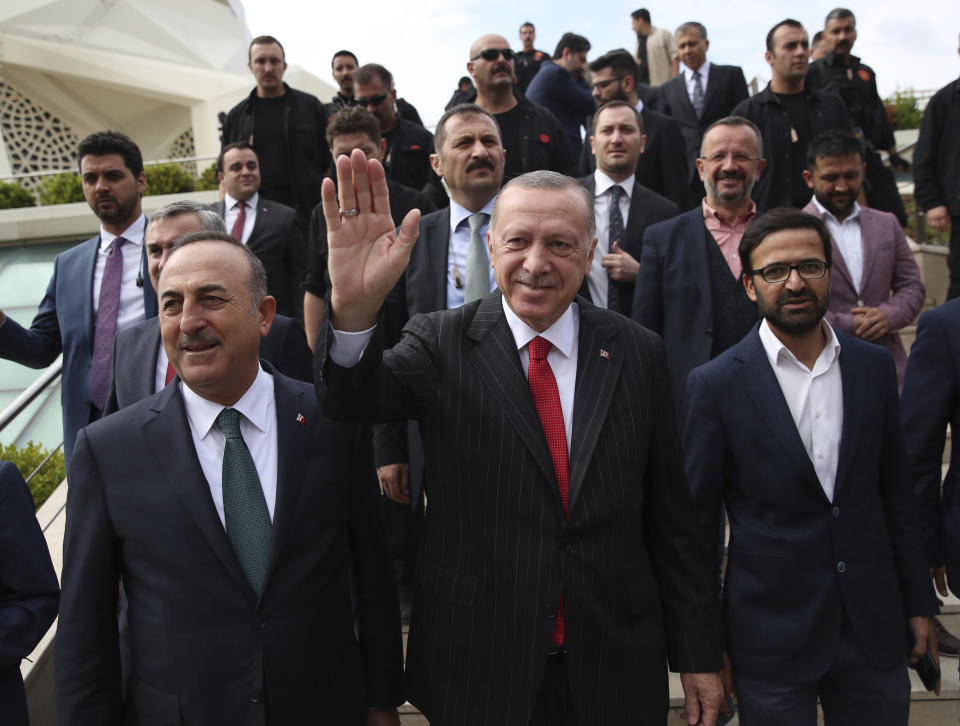 Turkey's President Recep Tayyip Erdogan waves to his supporters after Friday prayers, in Istanbul, Friday, Oct. 11, 2019. Turkish Foreign Minister Mevlut Cavusoglu is at the left.(Presidential Press Service via AP, Pool)