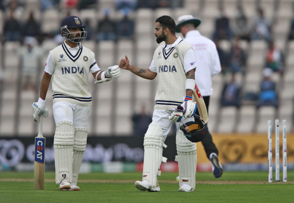 India's captain Virat Kohli, right, fist bumps with batting partner Ajinkya Rahane as they walk off the field after bad light stopped play during the second day of the World Test Championship final cricket match between New Zealand and India, at the Rose Bowl in Southampton, England, Saturday, June 19, 2021. (AP Photo/Ian Walton)