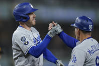 Los Angeles Dodgers' Freddie Freeman, left, celebrates with first base coach Clayton McCullough after hitting an RBI single during the sixth inning of the team's baseball game against the San Diego Padres, Thursday, Sept. 29, 2022, in San Diego. (AP Photo/Gregory Bull)