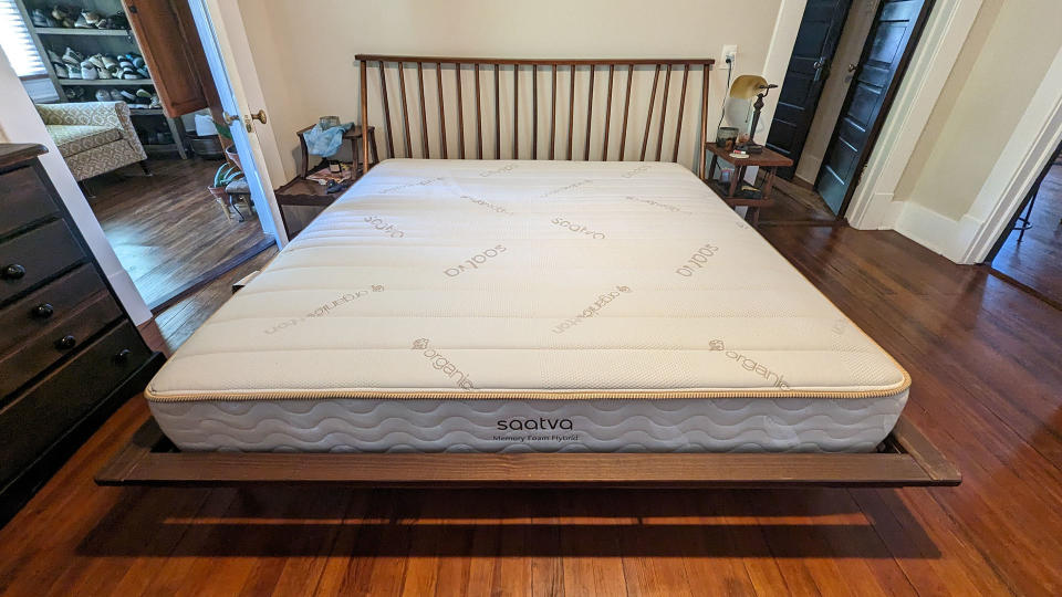 Saatva memory foam hybrid mattress on a bed frame in tester