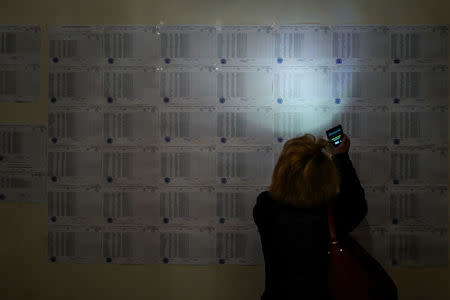 A woman uses her mobile phone to read voters list during a parliamentary election at a poling station in Yerevan, Armenia, April 2, 2017. Vahan Stepanyan/PAN Photo/Handout via REUTERS