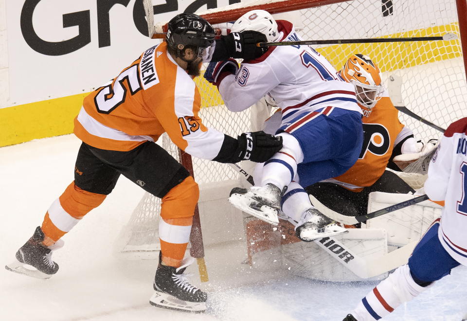 Montreal Canadiens center Max Domi (13) picks up a goaltender interference penalty as he is driven into Philadelphia Flyers goaltender Brian Elliott (37) by defenseman Matt Niskanen (15) during the second period of an NHL Eastern Conference Stanley Cup hockey playoff game in Toronto, Friday, Aug. 14, 2020. (Frank Gunn/The Canadian Press via AP)