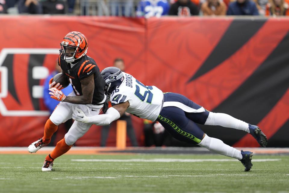 Cincinnati Bengals' Ja'Marr Chase (1) is tackled by Seattle Seahawks' Jordyn Brooks during the second half of an NFL football game, Sunday, Oct. 15, 2023, in Cincinnati. (AP Photo/Jeff Dean)