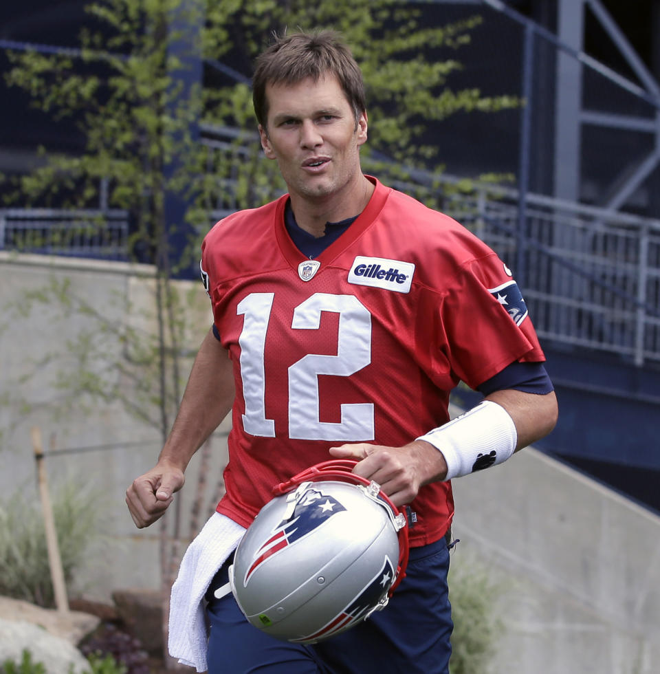 FILE - In this June 5, 2018, file photo, New England Patriots quarterback Tom Brady steps onto the field at the start of an NFL football minicamp practice, in Foxborough, Mass. Brady tops The Associated Press rankings of NFL quarterbacks at age 41. It’s the second straight season the New England Patriots’ star has edged Green Bay quarterback Aaron Rodgers, although Rodgers closed the gap this year. Brady is the league’s reigning MVP and coming off a record eighth trip to the Super Bowl while Rodgers is coming back from a shoulder injury that knocked him out for half of the 2017 season. (AP Photo/Steven Senne, File)