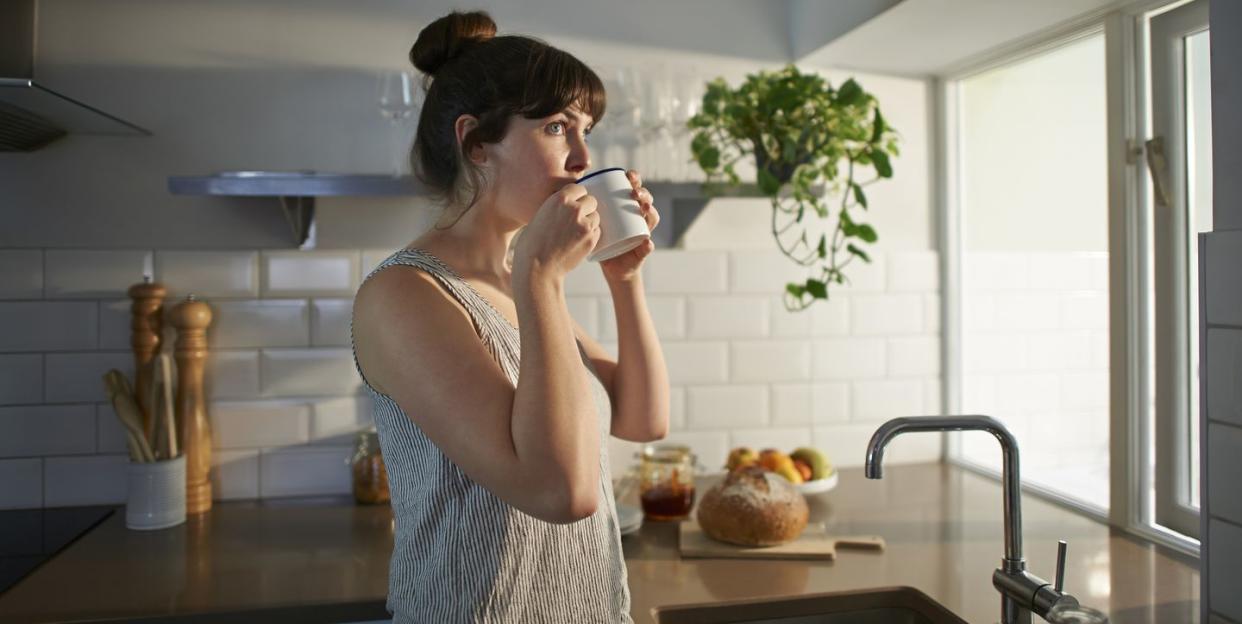 woman drinking from mug in zero waste kitchen