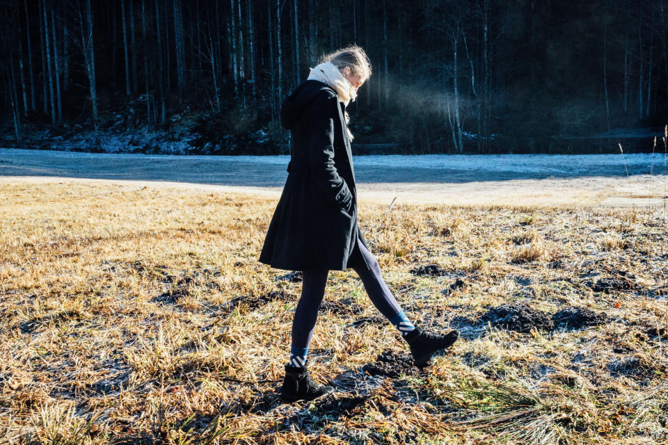 Girl walks on frosty ground in wintertime
