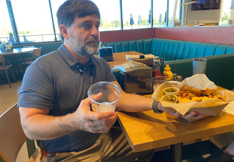 Bob Parker, who is consulting with Montgomery Whitewater's restaurant Eddy's, holds a drink and food in the new portable containers the restaurant will use. Parker is helping them with a new "fast casual" concept. The new menu goes into effect on Thursday, Dec. 7.