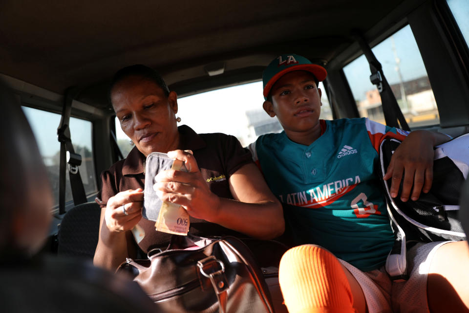 Baseball little league player Adrian Salcedo, 13, and his mother Diana Nunez, 44, take an informal taxi in Maracaibo, Venezuela. (Photo: Manaure Quintero/Reuters)