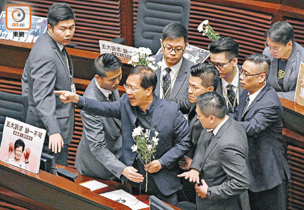 答問會上多名民主派議員帶上白花，又高叫口號抗議。