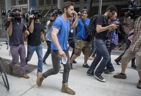 Actor Shia LaBeouf is surrounded by the media as he leaves Midtown Community Court in New York June 27, 2014. REUTERS/Brendan McDermid