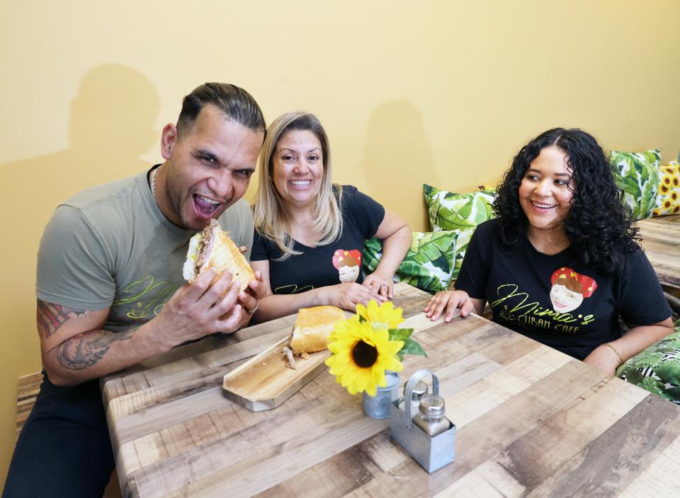 Mima's Cuban Cafe owners Hector eats a his famous Cuban sandwich as wife Abby Morales with daughter Alexandra watch on Friday, Feb. 9, 2024.