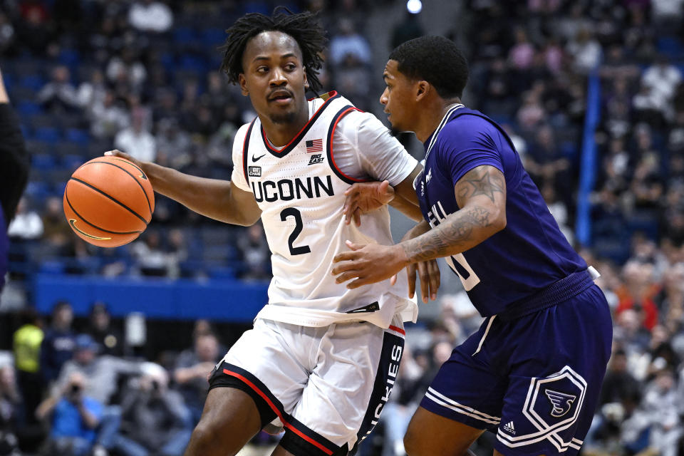 UConn's Tristen Newton is guarded by Stonehill's Tony Felder in the first half of an NCAA college basketball game, Saturday, Nov. 11, 2023, in Hartford, Conn. (AP Photo/Jessica Hill)