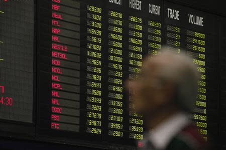 A man stands near an electronic board displaying stock prices during a trading session at Karachi Stock Exchange February 6, 2014. Pakistan's Karachi Stock Exchange is investigating whether staff profited from years of unauthorised access to real time trading data in a market that has rocketed more than 450 percent since 2009. REUTERS/Akhtar Soomro