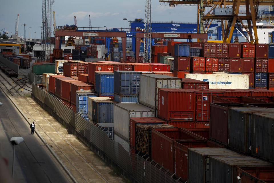 A man walks past containers at Lisbon port during a dock workers strike, Tuesday, Aug. 14, 2012. Portuguese dock workers went on strike against new labor laws that the Portuguese government wants to apply in the sector. The government has been enacting austerity economic measures linked to a euro 78 billion ($96 billion) bailout in 2011. (AP Photo/Francisco Seco)