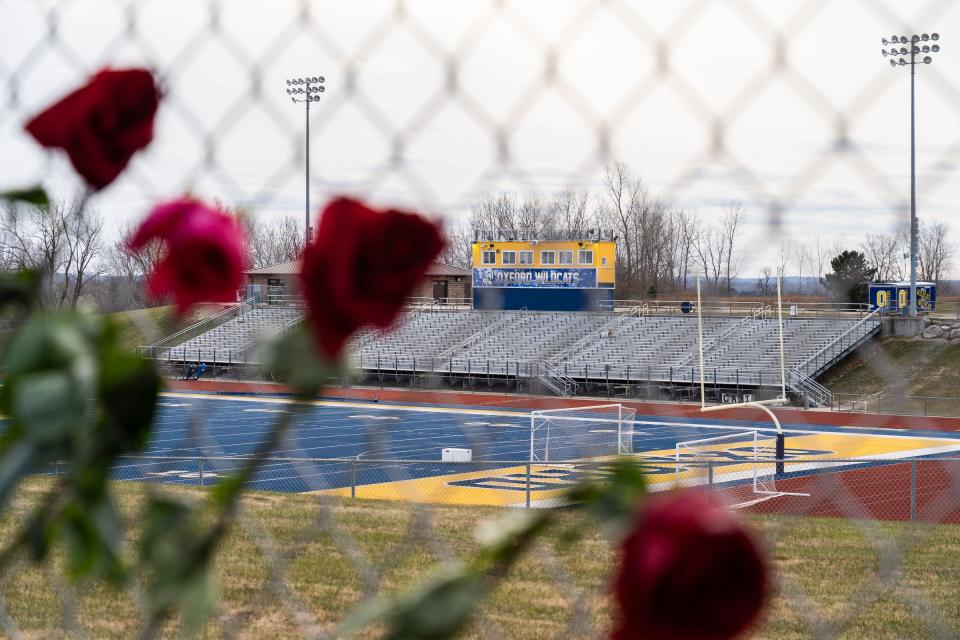 Roses are left on a fence around the Oxford High School football field on December 7, 2021, after an active shooter situation at Oxford High School that left four students dead and multiple others with injuries.
