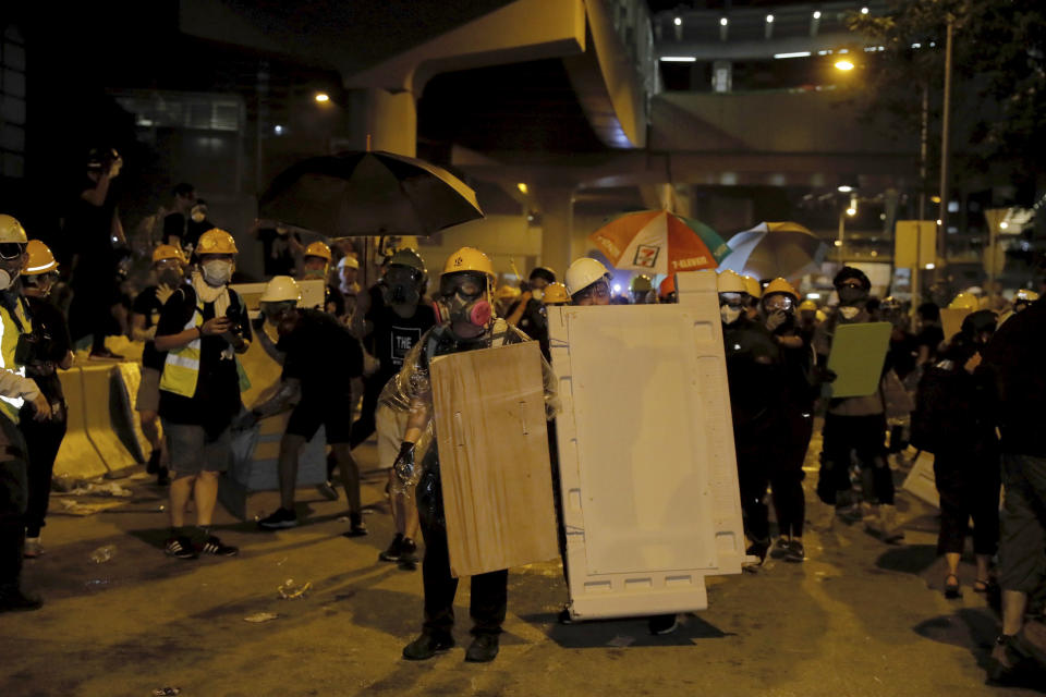 Protesters prepare to defend against police action at the Legislative Council in Hong Kong, during the early hours of Tuesday, July 2, 2019. Protesters in Hong Kong took over the legislature's main building Friday night, tearing down portraits of legislative leaders and spray painting pro-democracy slogans on the walls of the main chamber.(AP Photo/Kin Cheung)