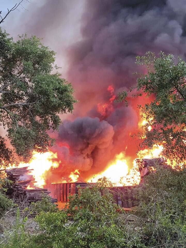 Smoke and fire fill the air from a blaze at National Salvage and Services Corp., on Monday, Aug. 2, 2021 near Selma, Ala. The fire that apparently started with a lightning strike and grew so large it showed up on weather radar engulfed a pile of thousands of railroad ties at a recycling plant in rural west Alabama. (Lane Frazer via AP)