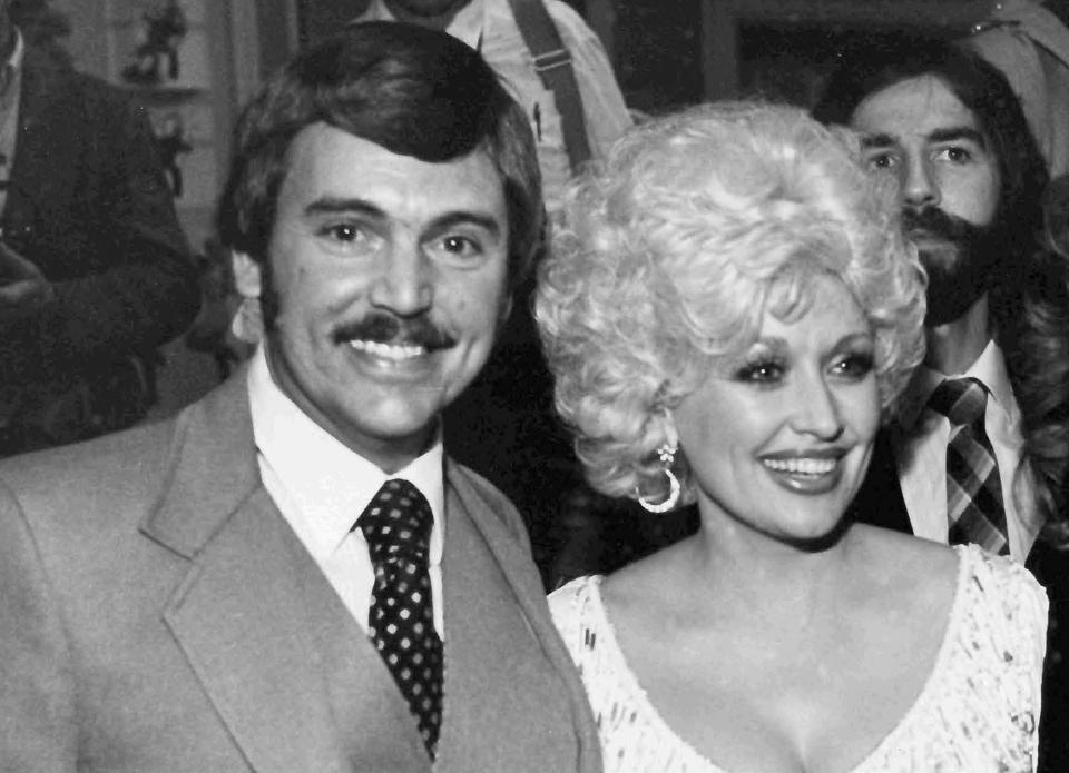 In this undated photo, Nashville, Tenn., newsman Joe Edwards, who has been writing the "Nashville Sound" column for nine years and knows everyone in the country music industry, poses with friend, actor and singer Dolly Parton at an awards reception. Edwards, who chronicled Tennessee news for more than 40 years as a newsman for The Associated Press and helped "Rocky Top" become a state song, died Friday, Feb. 3, 2023. He was 75. (AP Photo/Mark Humphrey)