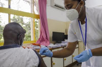 Khamis Juma, left, receives an injection of the 'Covishield'' coronavirus vaccine manufactured by the Serum Institute of India, from nurse Amelie Richmond, right, at a hospital in the capital Victoria, Mahe Island, Seychelles Wednesday, Feb. 24, 2021. The president of the Indian Ocean island nation of Seychelles says he hopes enough residents will soon be vaccinated against COVID-19 to stop the spread of the virus, hoping to achieve herd immunity by mid-March by vaccinating about 70% of the population. (AP Photo)