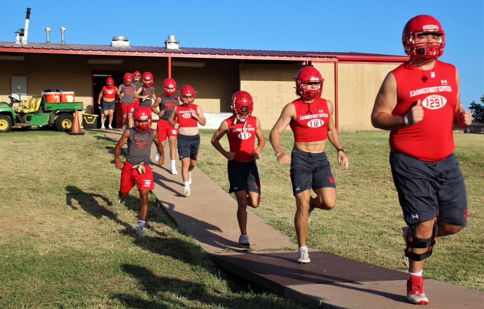 Albany players run from the locker room toward the practice field Monday to begin workouts for the 2023 football season. Albany went 14-2 last year as longtime head coach Denney Faith won his first state title.