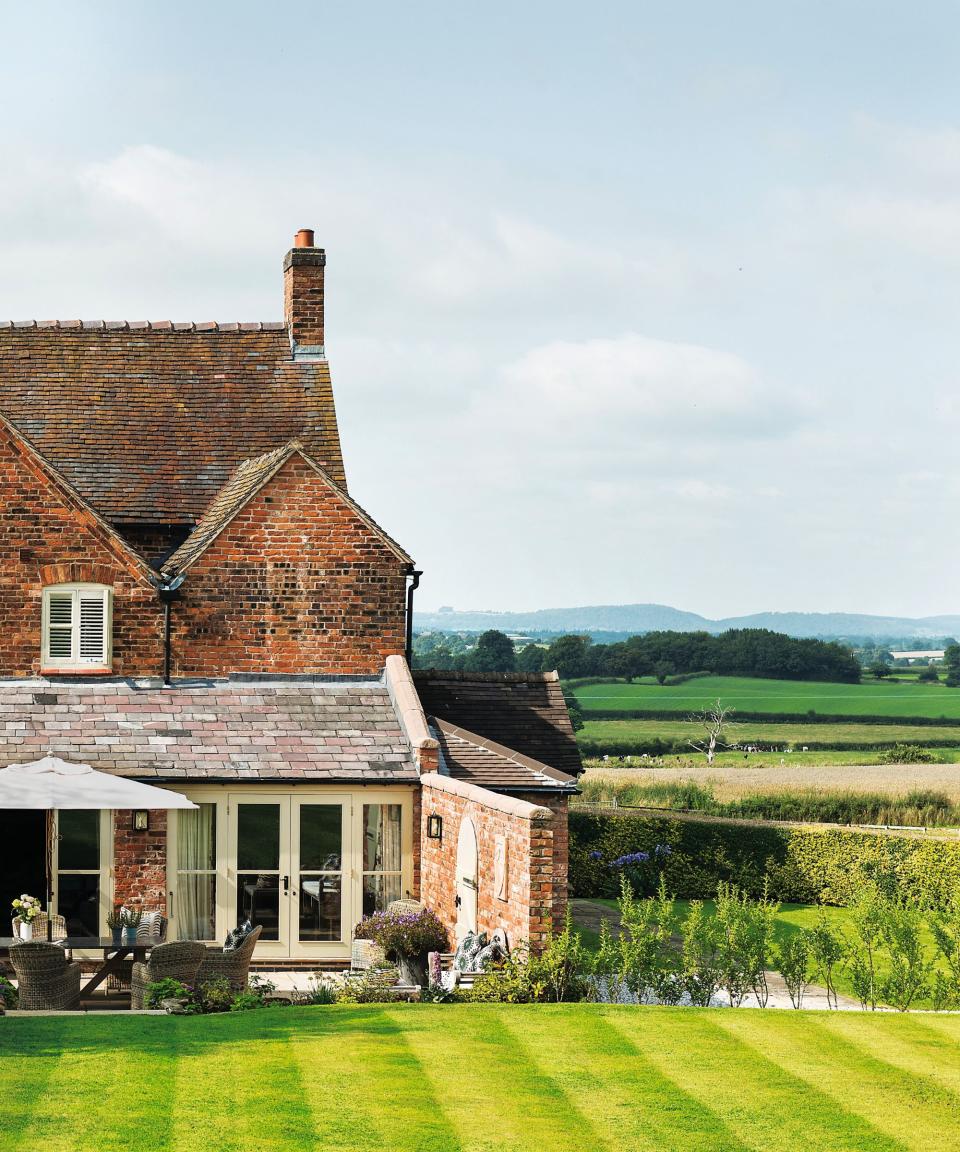 Brick house, lawn, hedge, cream doors