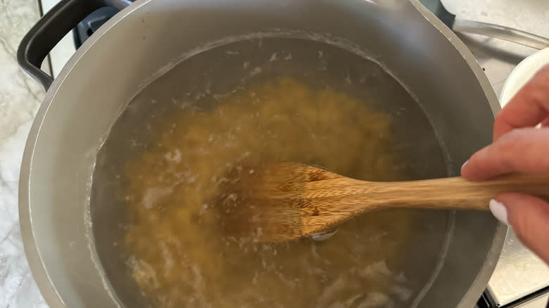 pasta cooking in pot with spoon