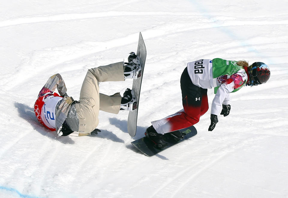 Lindsey Jacobellis of the United States crashes in the women's snowboard cross semifinal as Canada's Dominique Maltais. tries to avoid her at the Rosa Khutor Extreme Park, at the 2014 Winter Olympics, Sunday, Feb. 16, 2014, in Krasnaya Polyana, Russia. (AP Photo/Sergei Grits)