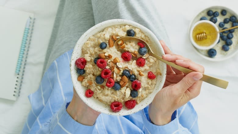 person eating oatmeal in bed