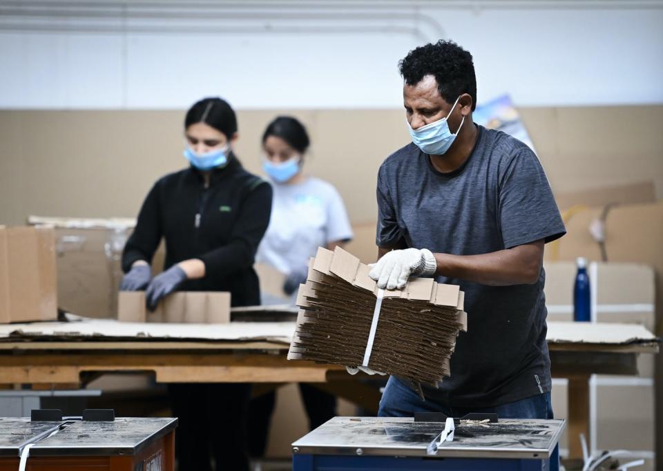 Workers manufacture cardboard petitions.